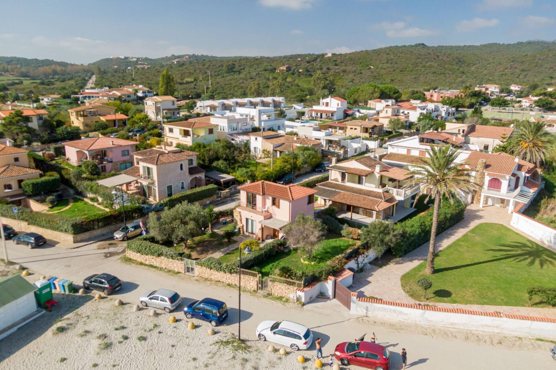 A residential area with houses, a parking lot, and a road.