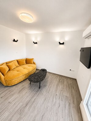 A modern living room with a sofa, a coffee table, and wall-mounted lighting.