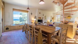 A spacious kitchen with a large island, wooden chairs, and pendant lighting.