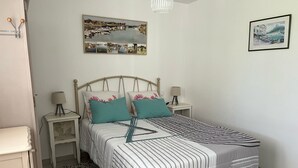 A neatly arranged bedroom with a bed, two bedside tables, a lamp, and a rug.
