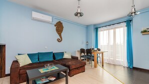 Una sala de estar con un sofá marrón, una mesa de centro y un comedor con una mesa y sillas.