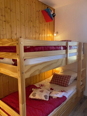 A bunk bed with two levels, wooden walls, and a small shelf above the top bunk. - Studio Yomeo - LA JOUE DU LOUP - Pied des pistes - 30 M² - 5 Pers 3 +++ (Dévoluy)