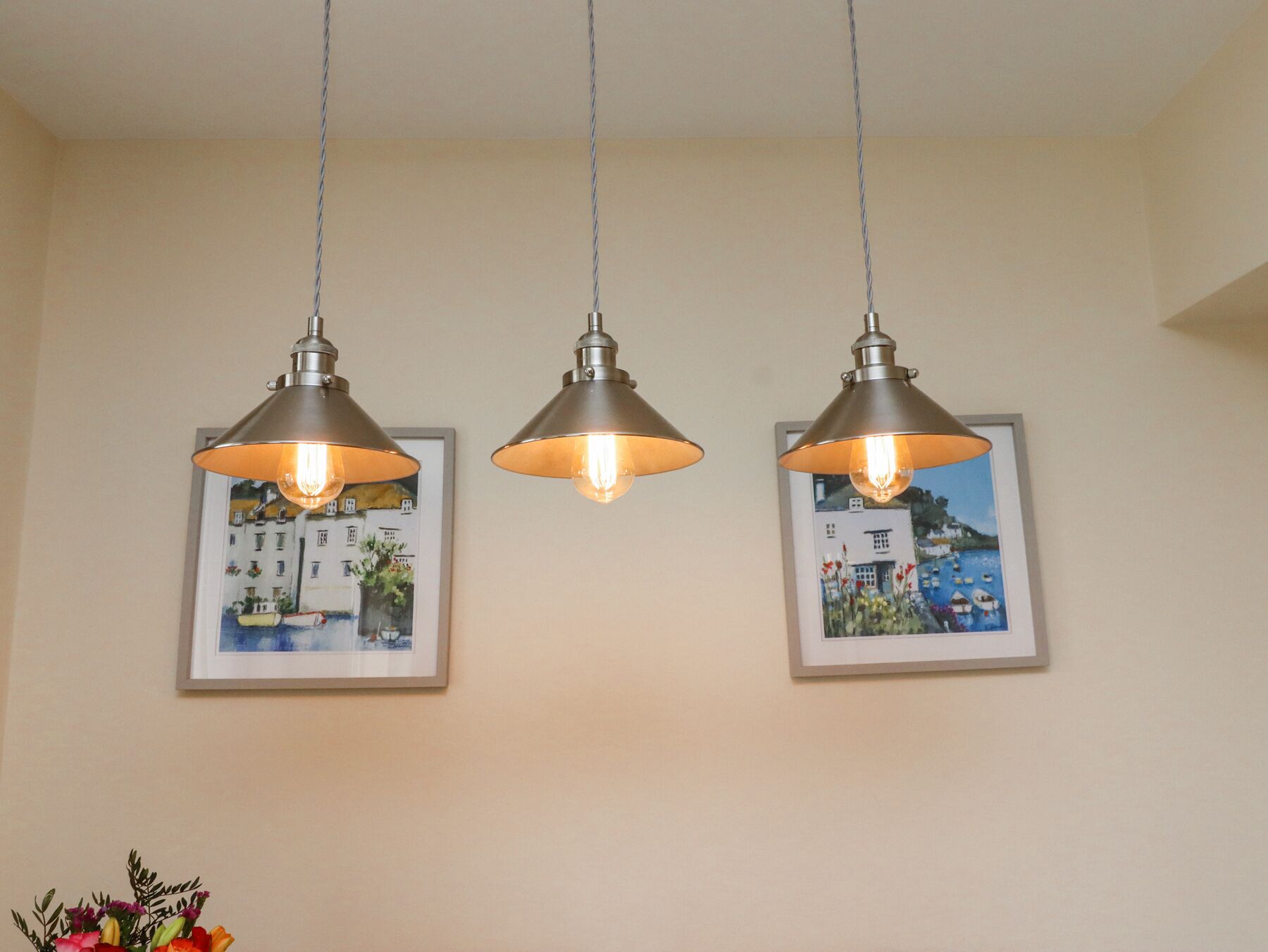Three pendant lights with a metallic finish hanging from the ceiling.