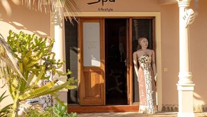 Een gebouw met een bord waarop 'Ocean Spa lifestyle' staat en een standbeeld van een vrouw in de ingang.