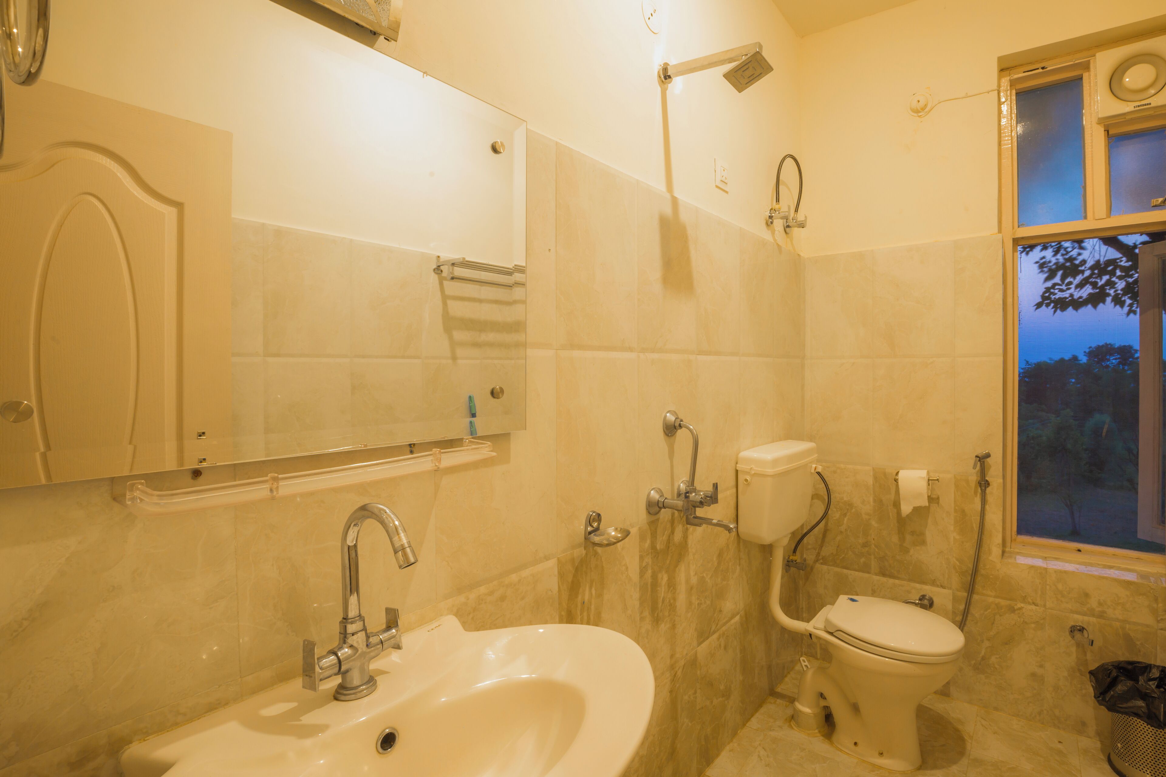 A bathroom with a sink, toilet, and a mirror.