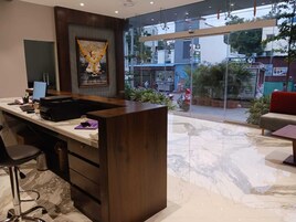 Un espacio de oficina moderno con un escritorio, una silla y un ventanal con vistas a la calle.