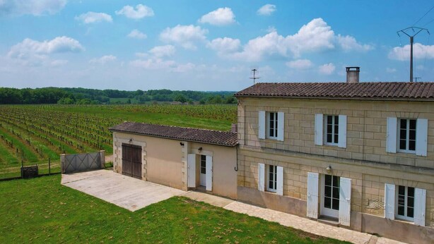 A two-story building with a tiled roof, a small attached structure, and a paved driveway leading to a gate. - Heated pool, House in the heart of the vineyards (Puisseguin)