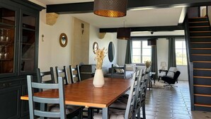 A dining area with a wooden table, chairs, and a vase of dried flowers. There is a staircase leading to an upper level. - Heated pool, House in the heart of the vineyards (Puisseguin)