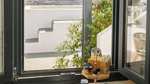 A window with a view of a flat landscape and distant hills. - Amphora Meltemi Seaview Gem w Private Jacuzzi (Santorini)