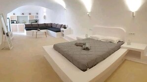 Un dormitorio moderno con una cama grande, un sofá y un escritorio.