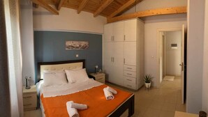 A bedroom with a bed, a nightstand, a wardrobe, and a door leading to another room.