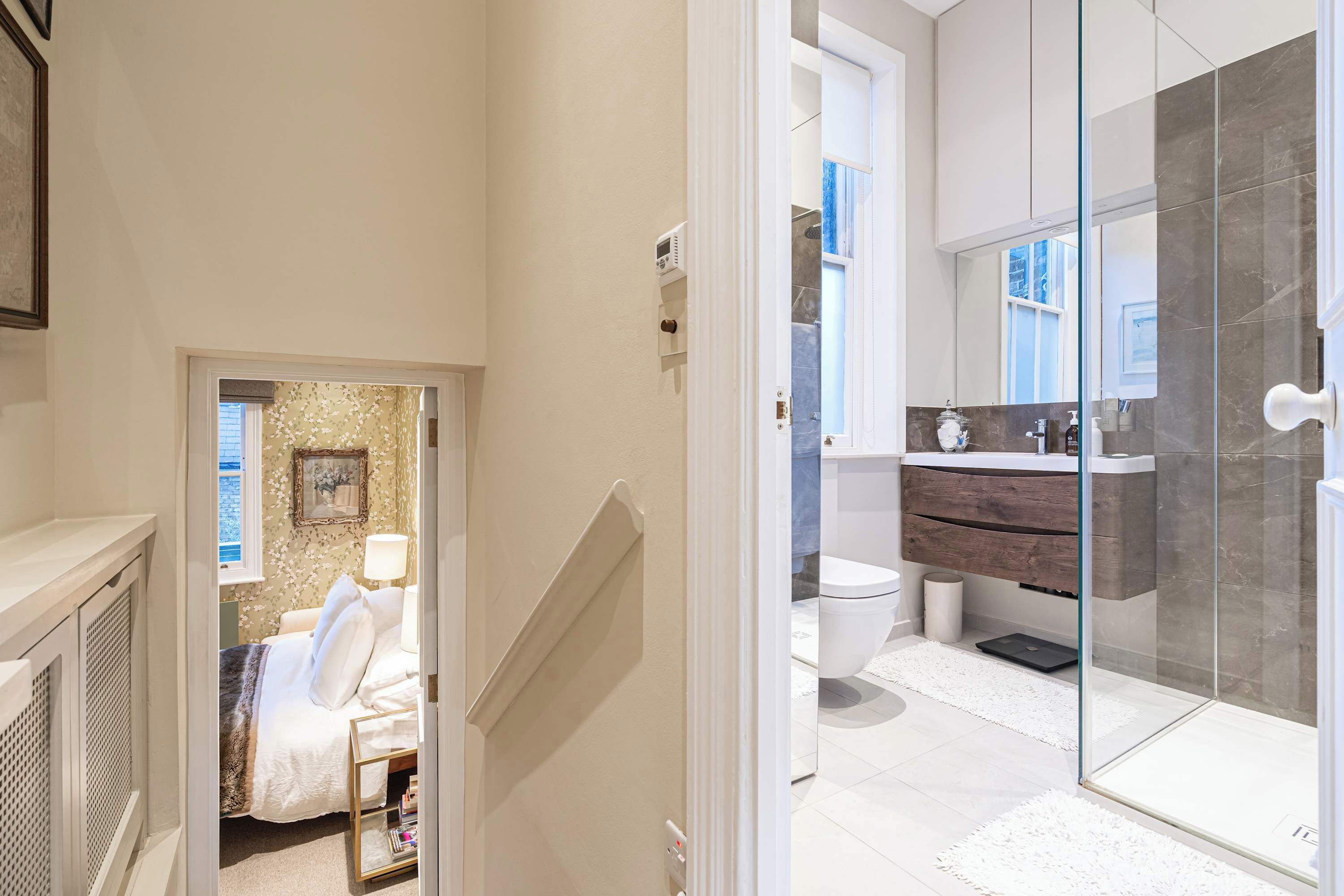 A modern bathroom with a glass shower, a white toilet, and a wooden vanity.