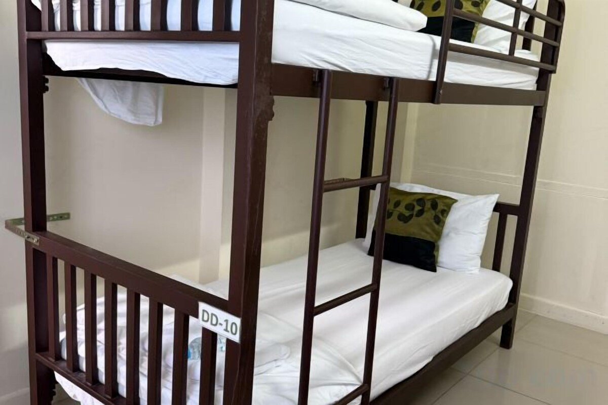 A bunk bed with a label 'DD-10' and a pillow with a leopard print design.