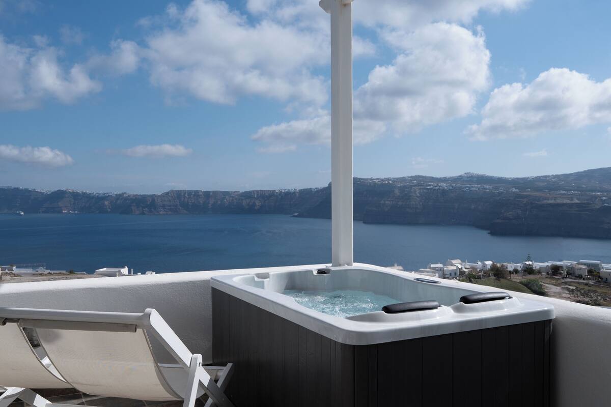 A hot tub with a view of the sea and mountains.