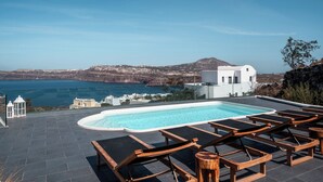 A rooftop pool area with lounge chairs, a swimming pool, and a view of the sea and mountains. - Zen Villas (Akrotiri)