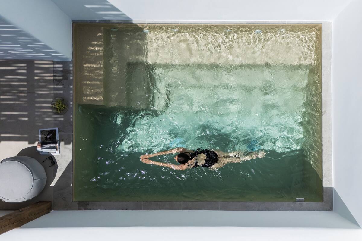 A modern indoor swimming pool with a person swimming.