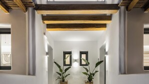 Un escalier menant à un palier où sont placés deux pots de plantes, un de chaque côté.