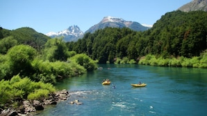 A river surrounded by lush greenery and mountains. - Lago Rosario Lodge (Trevelin)