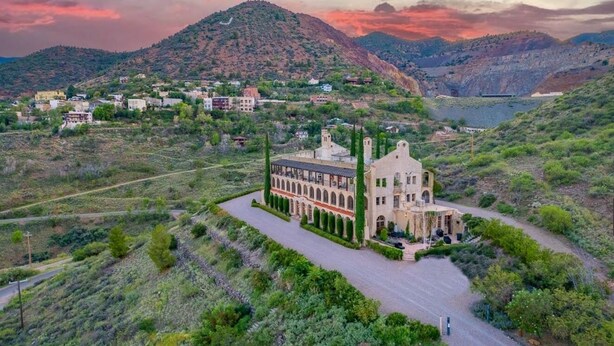 A large building with a central courtyard, surrounded by greenery and hills. - Little Daisy Jerome Historic Mansion Sedona Views (Sedona)