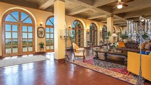 A spacious lobby with high ceilings, large arched windows, and a central seating area with a coffee table and chairs. - Little Daisy Jerome Historic Mansion Sedona Views (Sedona)
