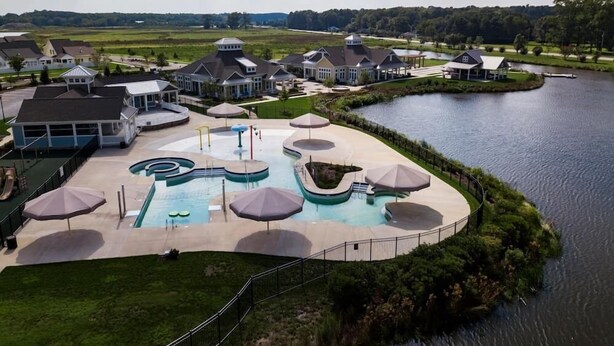 A residential area with a swimming pool, houses, and a lake. - 4 BR Beauty-Millville by the Sea~ Minutes to Bethany Beach -23548 Bonfire Way (Millville)