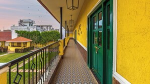 A corridor with a patterned floor, green doors, and a yellow wall. - Greenfields Resort (Bhopal)