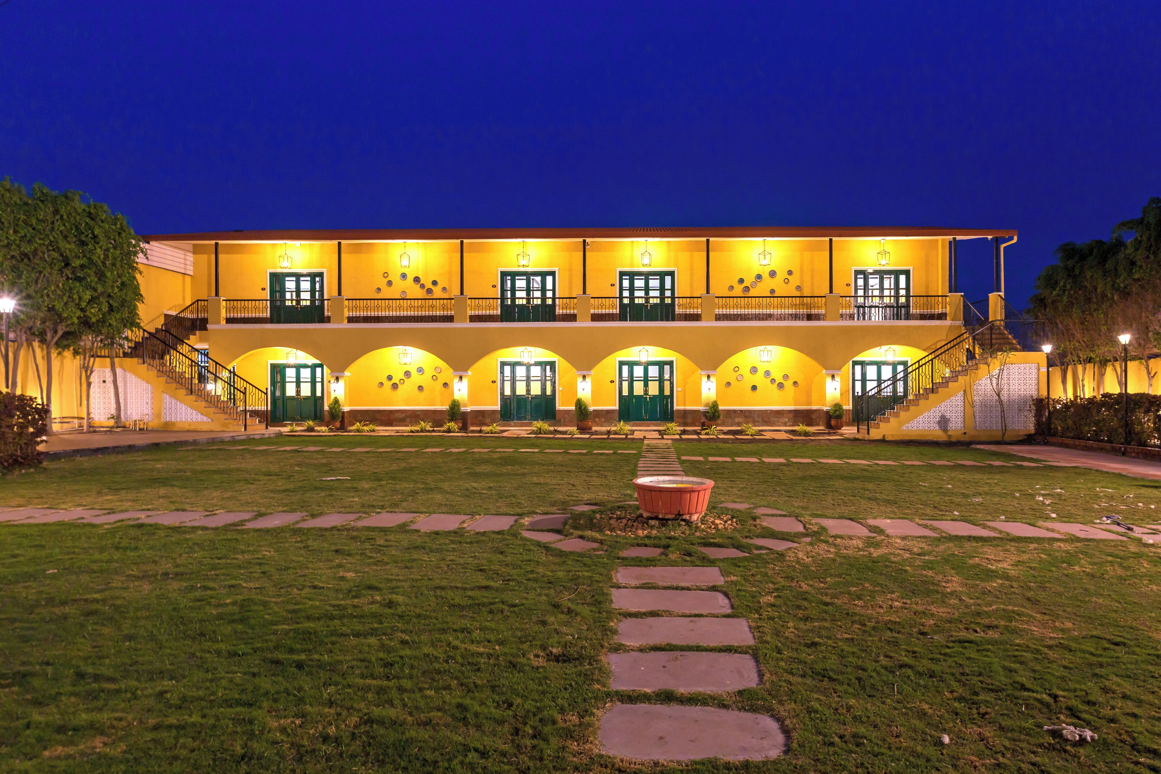 A hotel with a symmetrical facade, multiple balconies, and a central courtyard with a fountain.