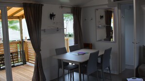 A room with a table and chairs, a door, and a window with curtains.