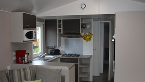 A compact kitchen with a microwave, toaster, and stove.