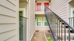 A narrow outdoor corridor with a concrete path, metal railings, and a small garden area with plants. - 9 Mi to Dtwn Dallas: Cozy Couple's Getaway (Dallas)