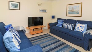 A living room with a TV, two sofas, and a coffee table. - 8 Dartmouth House (Dartmouth)