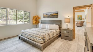 A bedroom with a large bed, a nightstand, a wooden headboard, a window with a view, and a painting on the wall. - On-site River Access: Mtn-view Ouray Oasis! (Ouray)