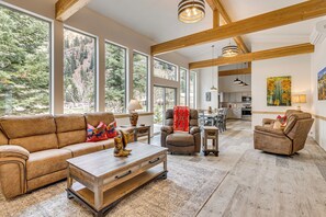 A spacious living room with large windows, a wooden ceiling, and a cozy seating area. - On-site River Access: Mtn-view Ouray Oasis! (Ouray)