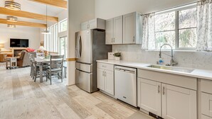 A modern kitchen with white cabinetry, stainless steel appliances, and a large window providing natural light. - On-site River Access: Mtn-view Ouray Oasis! (Ouray)