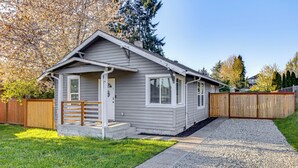 A single-story house with a front porch, a wooden fence, and a gravel driveway.