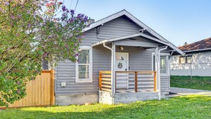 A single-story house with a front porch, a wooden fence, and a small garden.