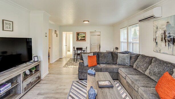 A modern living room with a sectional sofa, a flat-screen TV, and a coffee table.