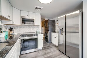 A modern kitchen with stainless steel appliances, white cabinetry, and a granite countertop. - Walk to Casino: Condo w/ Balcony in Atlantic City! (Atlantic City)