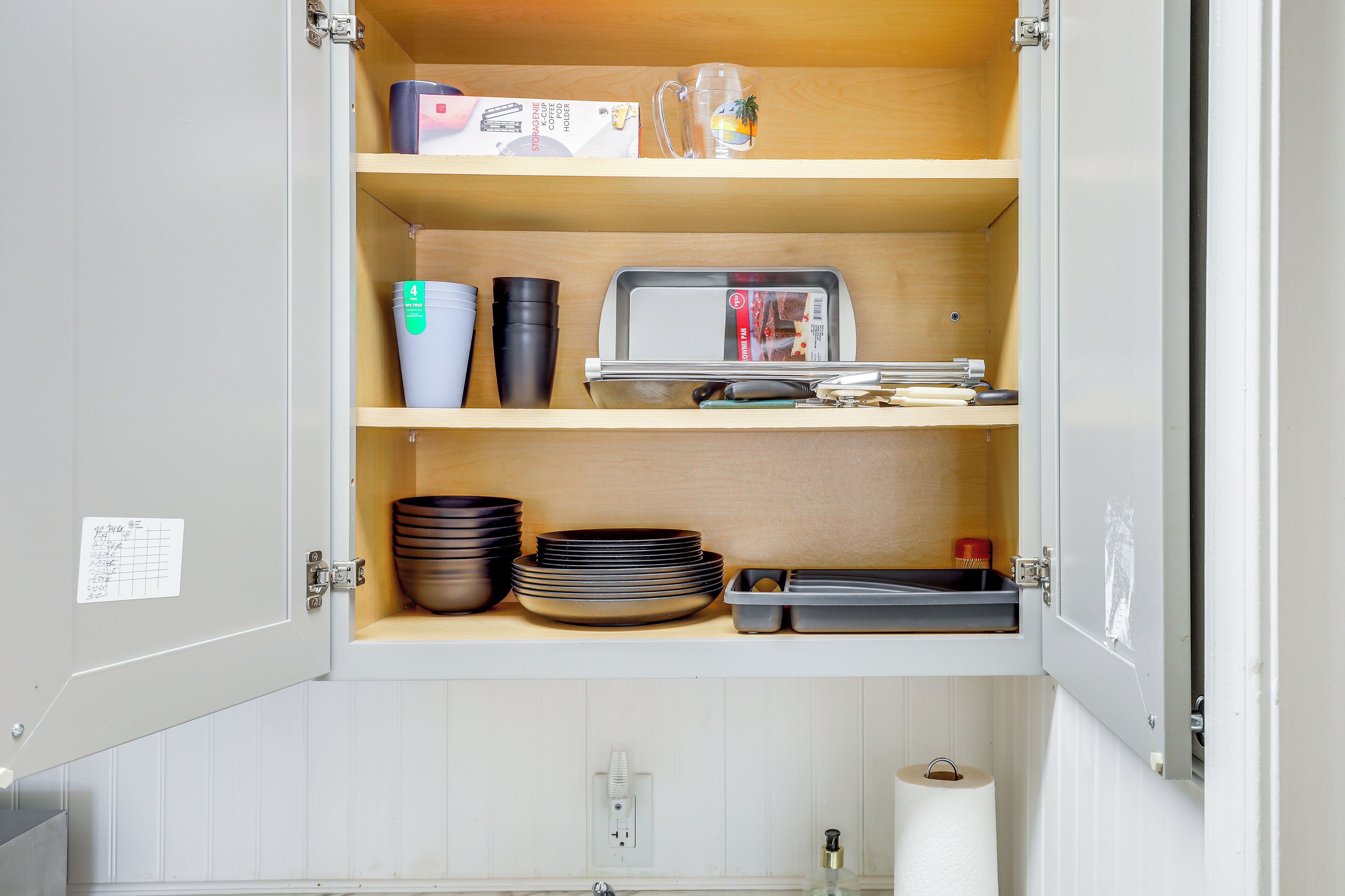 Un armario de cocina con estantes que contienen diversos utensilios de cocina.