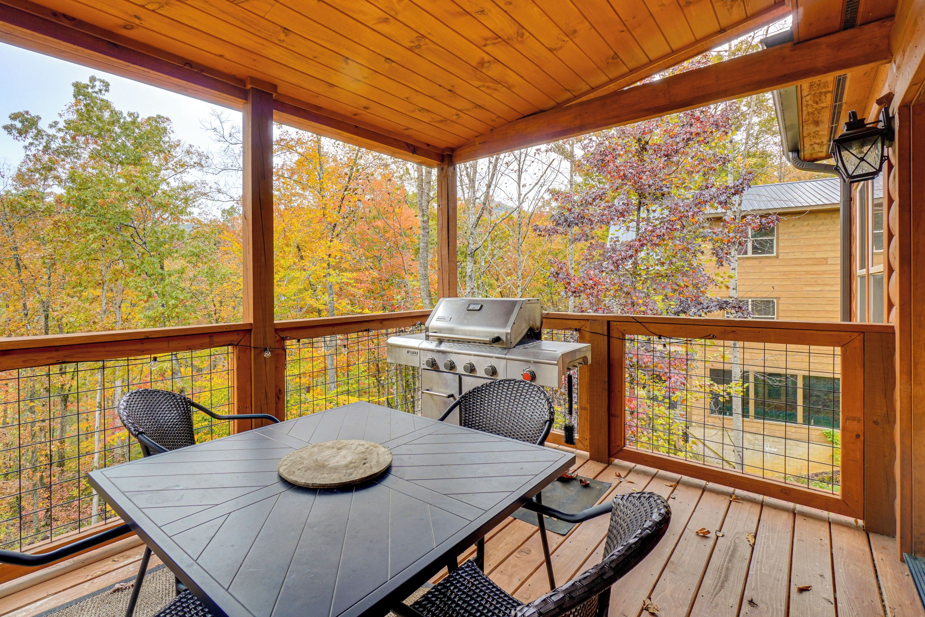 Une terrasse extérieure couverte, équipée d’un barbecue, d’une table à manger et de chaises.
