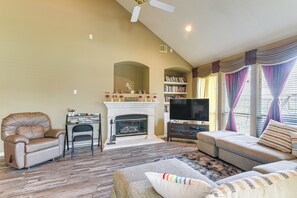 A living room with a fireplace, leather armchair, sofa, and a television. - Patio, BBQ & Yard: Family Retreat in Pearland (Pearland)