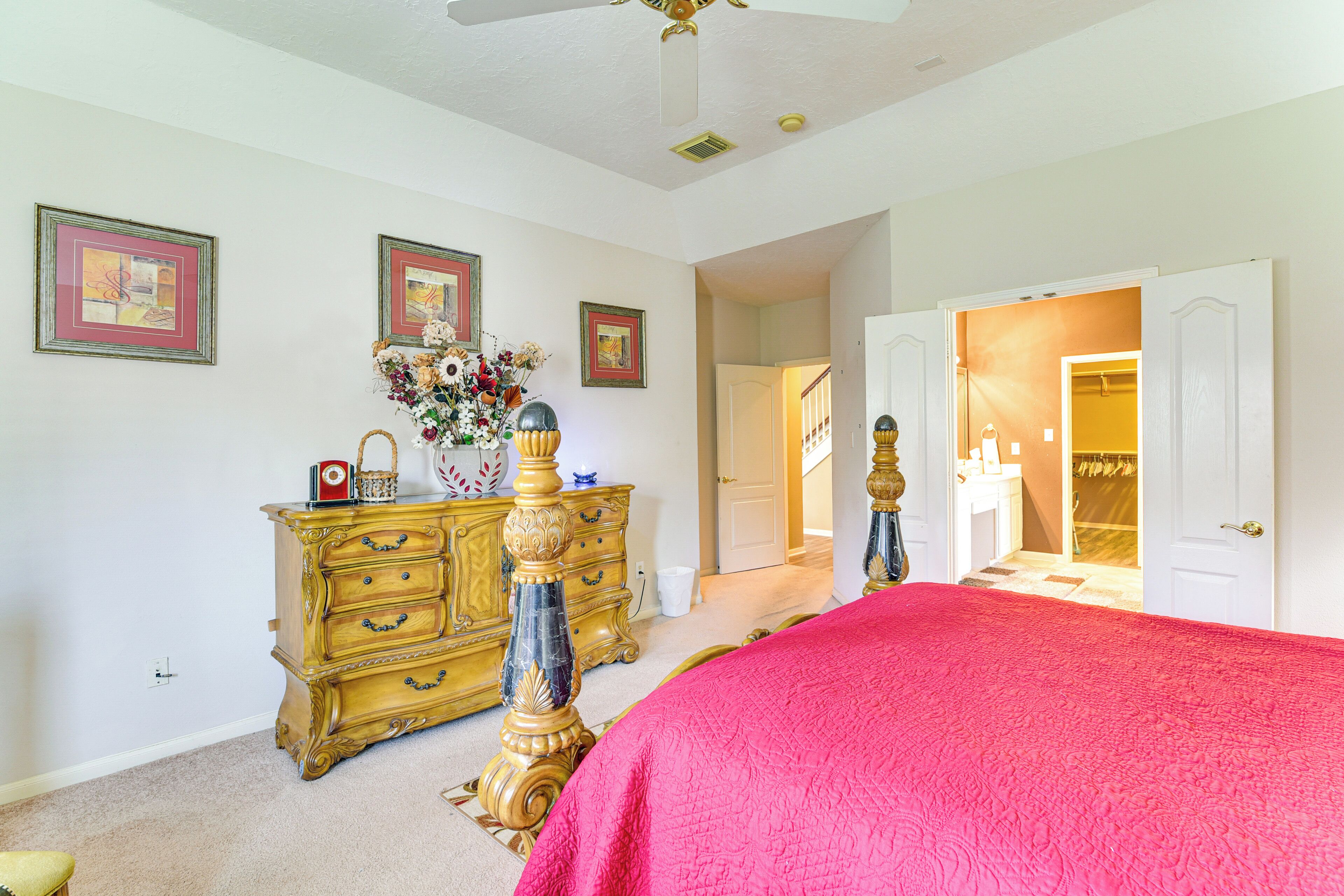 A bedroom with a large bed, a dresser, and a closet.