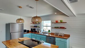 Una cocina moderna con una isla central, electrodomésticos integrados y armarios de madera.