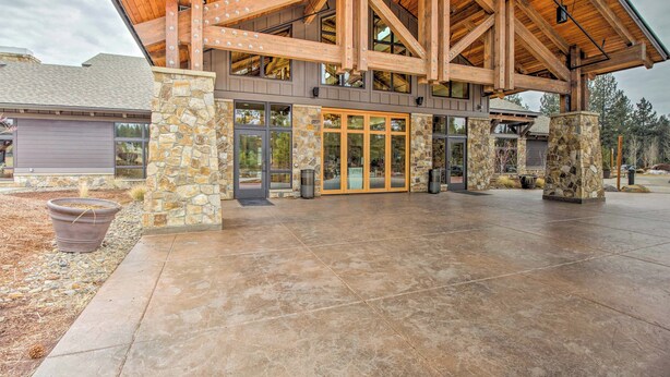 A building with a stone facade, large glass doors, and a wooden roof structure.