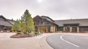 A building with a curved driveway, a stone facade, and a large entrance.