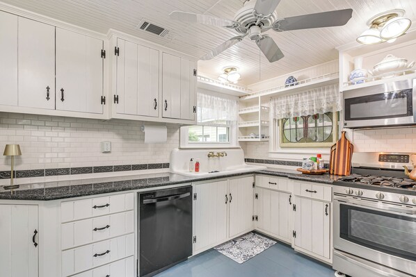 A kitchen with white cabinets, a dishwasher, a stove, and a microwave. - Galveston Bay Retreat: Historic La Porte Home! (La Porte)