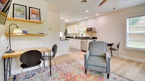 A modern living room with a wooden desk, black chairs, a patterned rug, and a ceiling fan. - 2 Mi to Downtown: Greensboro Home By Park! (Greensboro)