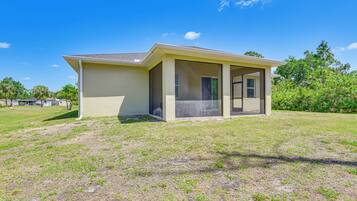 Enjoy a peaceful retreat in this single-story home with a covered porch and grassy surroundings.