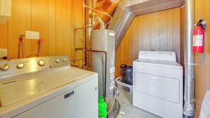 Un espace buanderie équipé d’un lave-linge, d’un sèche-linge et d’un chauffe-eau.