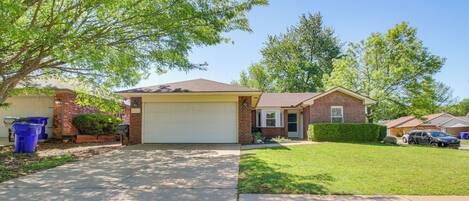 A suburban house with a garage, a front yard, and a driveway.